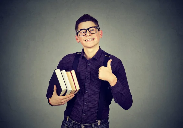 Jovem nerd homem em óculos com livro mostrando polegar para cima — Fotografia de Stock