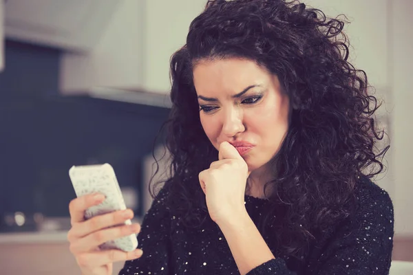 Molesto mujer joven confundida demandando mensaje de texto de lectura de teléfono móvil — Foto de Stock