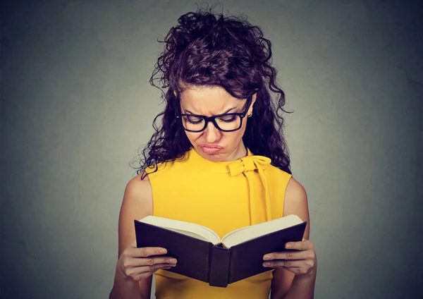 Thoughtful displeased woman reading a book — Stock Photo, Image