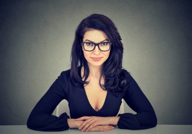 Kameraya bakarak masada oturan iş kadın 