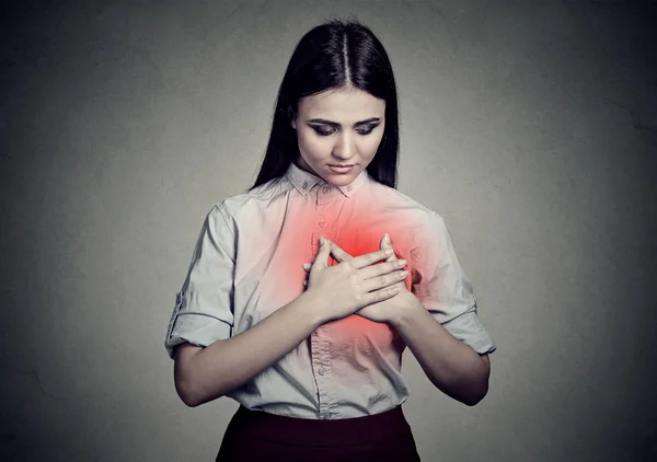 Mujer enferma con dolor de corazón sosteniendo tocándose el pecho con las manos — Foto de Stock