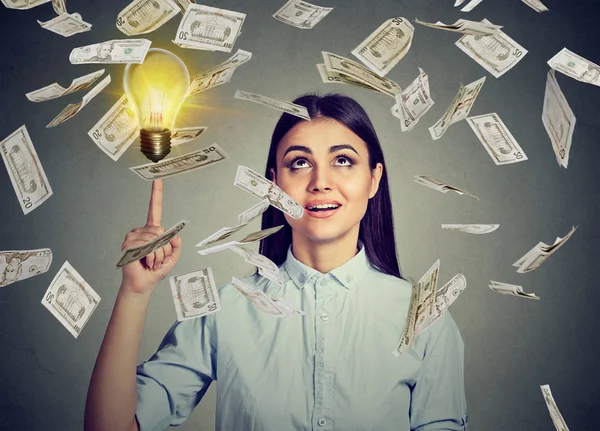 Frau im Geldregen zeigt auf Idee Glühbirne — Stockfoto