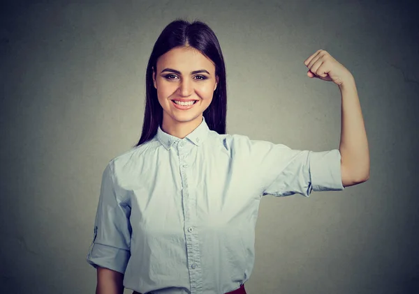 Joven mujer feliz flexionando los músculos mostrando fuerza — Foto de Stock