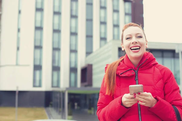 Счастливая молодая женщина со смартфоном на открытом воздухе на фоне города . — стоковое фото