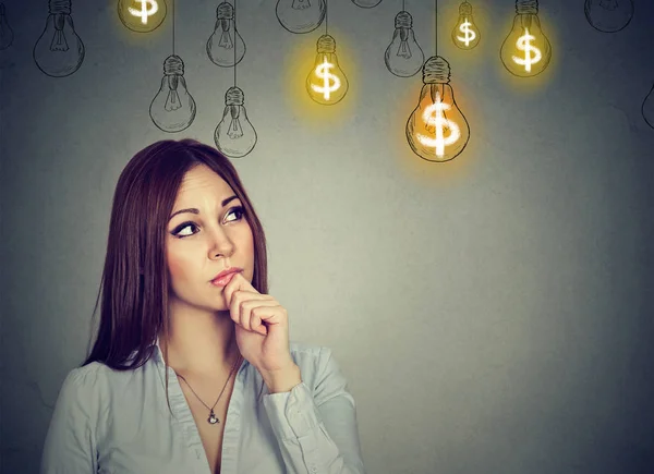 Retrato pensando mujer joven mirando a las bombillas de la idea del dólar por encima de la cabeza — Foto de Stock