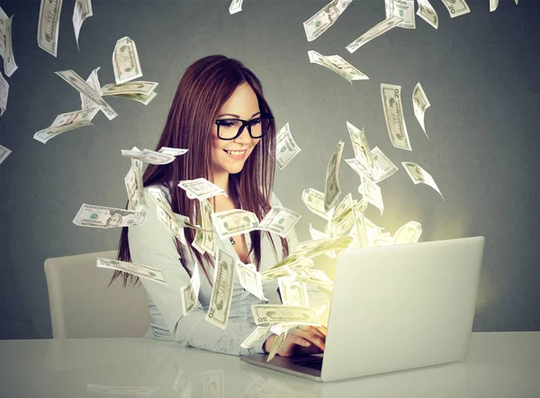 Mujer sentada en la mesa usando el trabajo en una computadora portátil haciendo dinero — Foto de Stock