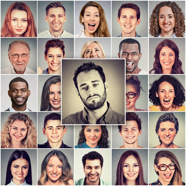 Szomorú ember boldog emberek csoportja között — Stock Fotó