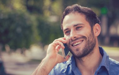 Cep telefonu açık havada üzerinde konuşan bir adam headshot 