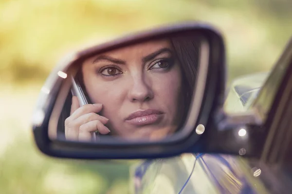 Mujer conduciendo en coche y hablando por su teléfono, molesto por la conversación — Foto de Stock