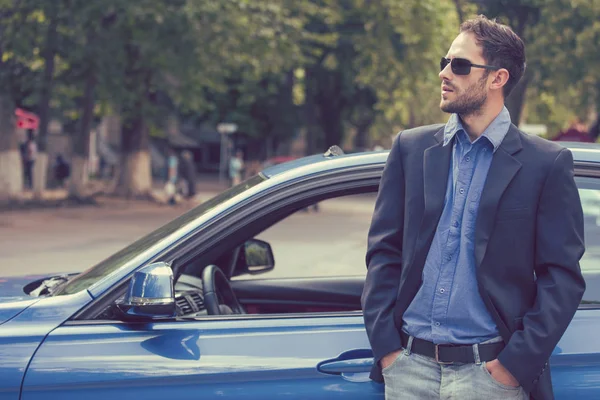 Pria tampan yang sukses berdiri di samping mobil barunya menikmati hari musim panas — Stok Foto