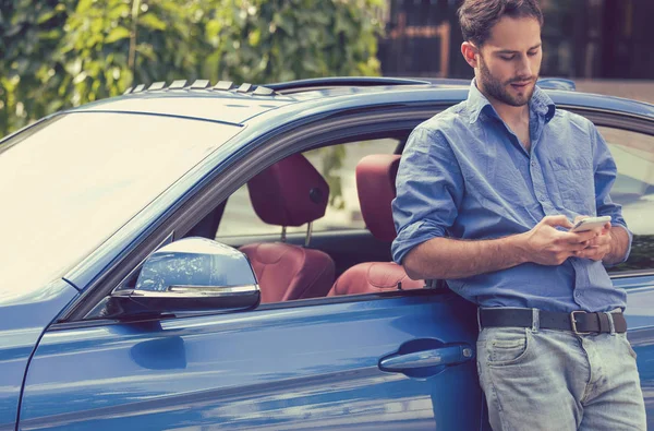 Uomo in piedi accanto alla sua auto sms sul telefono cellulare — Foto Stock