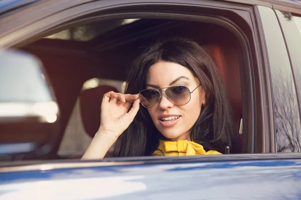 Conductora atractiva con gafas de sol sentada dentro de su coche —  Fotos de Stock