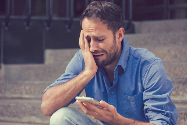 Aufgebrachter Mann schaut auf sein Handy im Freien — Stockfoto