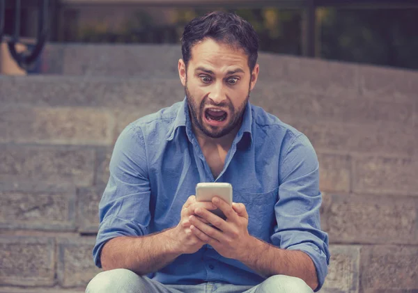 Hombre sorprendido mirando el teléfono móvil viendo malas noticias o leyendo mensajes de texto —  Fotos de Stock
