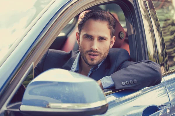 Hombre feliz comprador sentado en su nuevo coche listo para el viaje . — Foto de Stock