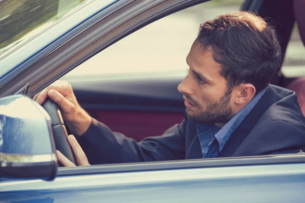 Seitenscheibenblick schläfrig erschöpft Mann am Steuer seines Autos. — Stockfoto