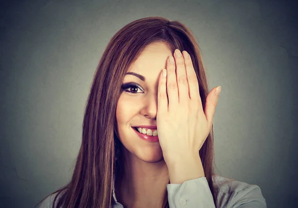 Lächelnde Frau mit Augen, mit der Hand geschlossen, die einen Teil ihres Gesichts bedeckt — Stockfoto