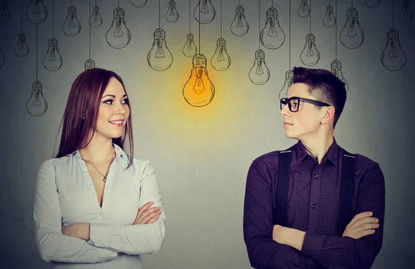 Concepto de habilidades cognitivas, masculino vs femenino. Hombre y mujer mirando la bombilla —  Fotos de Stock