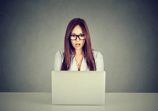 Ideges nő néz médiatartalom egy laptop online ült az asztalnál — Stock Fotó