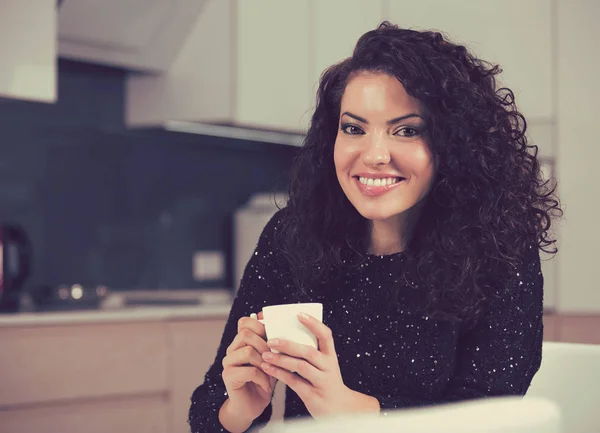 Женщина пьет кофе утром дома на кухне — стоковое фото