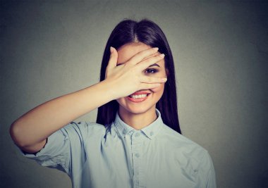 Utangaç bir kadın yüzü ürkek gülüyor gizleme. El ile gülümseyen sevimli kız