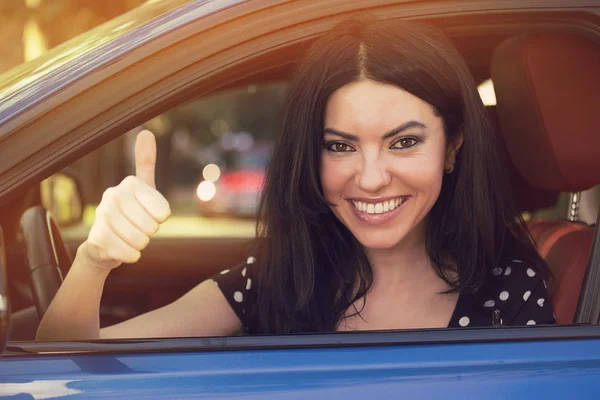 Ευτυχισμένη γυναίκα οδήγηση αυτοκινήτου της, και να δείχνει τον αντίχειρα επάνω. — Φωτογραφία Αρχείου