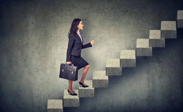 Businesswoman with briefcase stepping up a stairway career ladder Stock Image