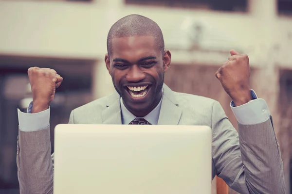 Feliz hombre exitoso con el ordenador portátil celebra el éxito fuera de la oficina corporativa — Foto de Stock