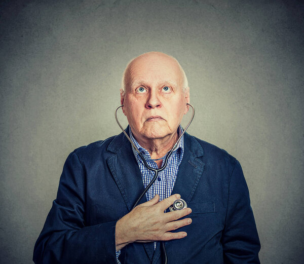 Старший слушает свое сердце стетоскопом
 