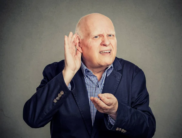 Hombre mayor, con dificultad auditiva, poniendo la mano en la oreja pidiendo a alguien que hable — Foto de Stock