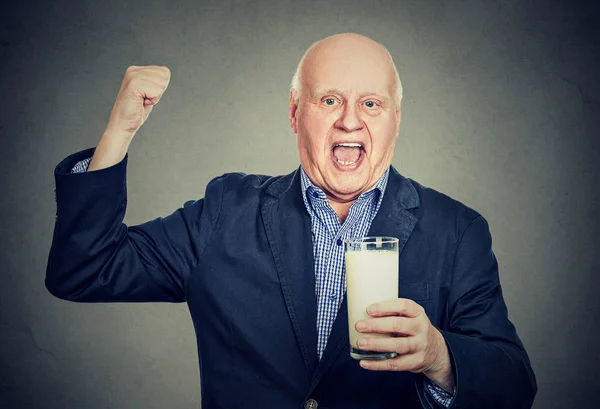 Emocionado caballero mayor sosteniendo un vaso de leche — Foto de Stock