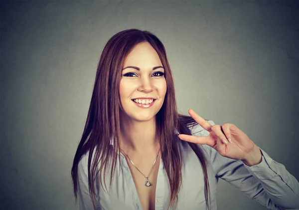 Mujer joven mostrando signo de victoria — Foto de Stock