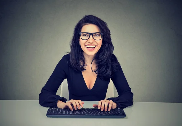 Glimlachend verbaasd vrouw te typen op een toetsenbord van de computer — Stockfoto