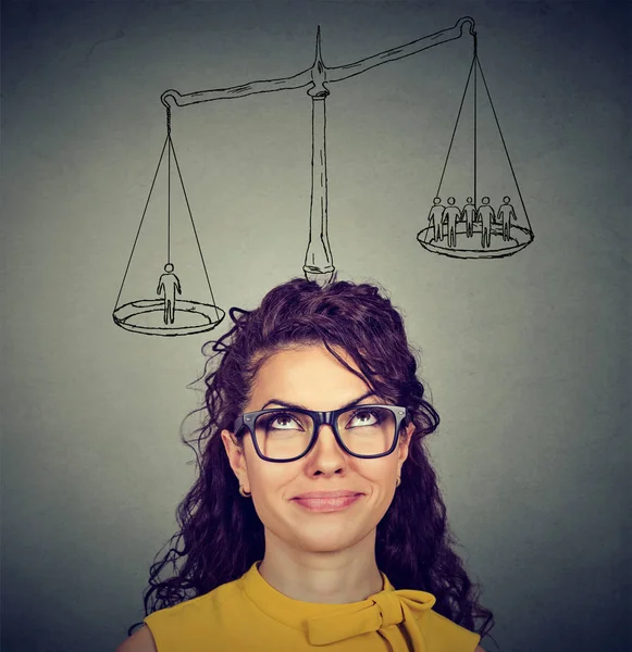 Woman making a decision with scale above head and people on a balance — Stock Image Woman making a decision with scale above head and people on a balance Royalty Free Stock Images