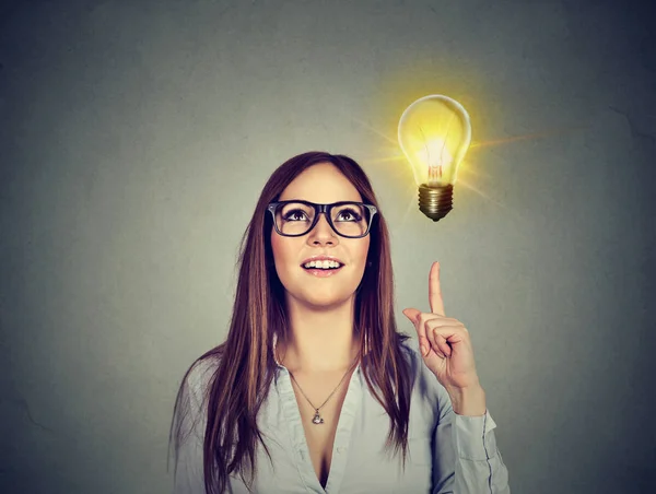 Frau zeigt auf helle Glühbirne. Erfolg wachsendes Geschäftskonzept — Stockfoto