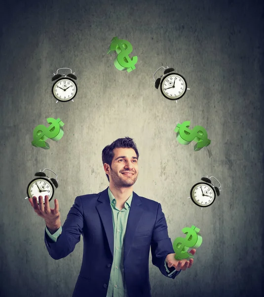 Time is money. Businessman juggling dollar signs and alarm clock — Stock Photo, Image