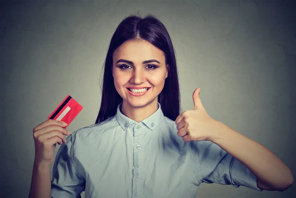 Sorrindo mulher segurando um cartão de crédito dando polegares para cima — Fotografia de Stock