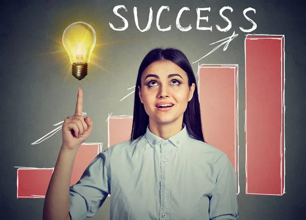 Femme réussie regardant vers le haut à l'ampoule d'idée avec la carte de succès croissante — Photo