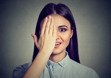 gülümseyen kadın, gözle, el ile onun yüzünü parçası kapsayan kapalı