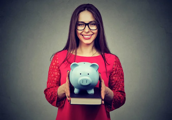 Student, happy woman, holding books and piggy bank in hands — Stock Photo, Image