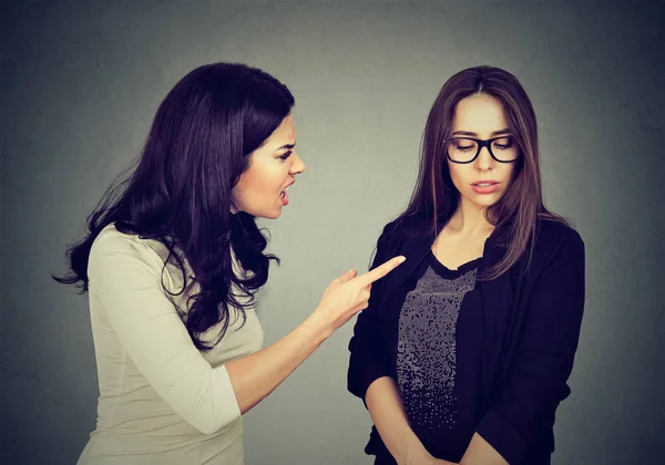 Angry woman scolding her scared shy young sister or friend — Stock Photo, Image