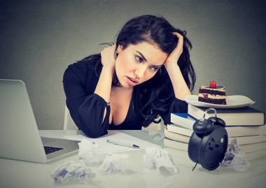 stressed woman sitting at desk in her office overworked craving sweet cake   clipart