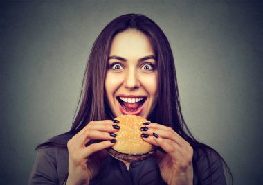 Fast food benim favorim. Tadı zevk bir hamburger yiyen Kadın 