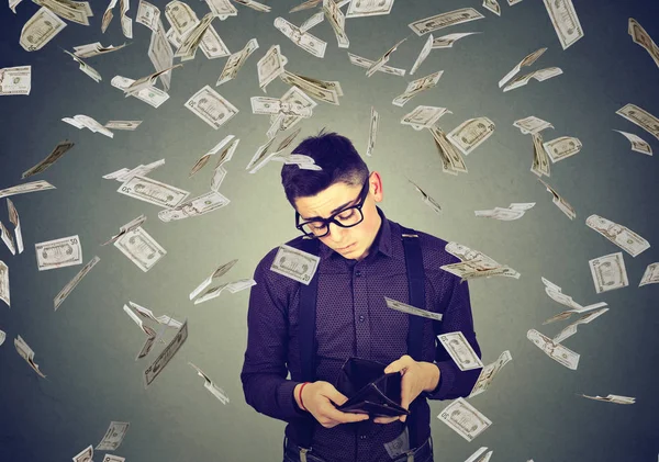 Sad man looking at his empty wallet under money dollar banknotes rain — Stock Photo, Image