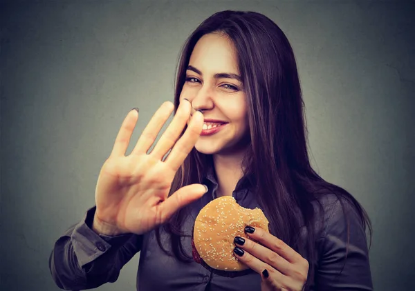 Mulher com hambúrguer rejeitando aconselhar sobre alimentação saudável — Fotografia de Stock