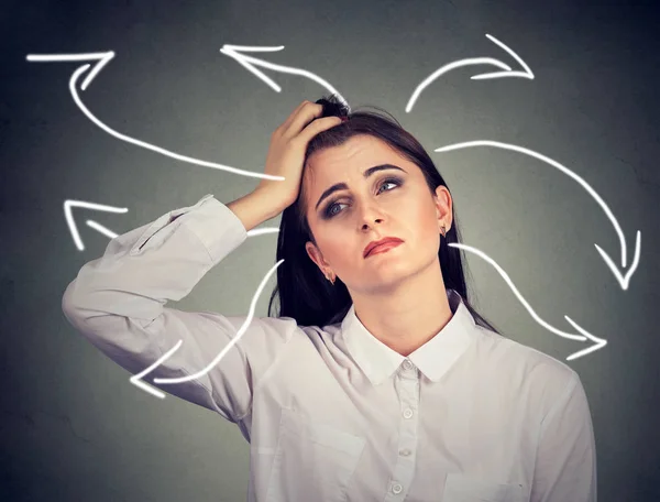 Confused woman with many twisted arrows coming out of her head — Stock Photo, Image