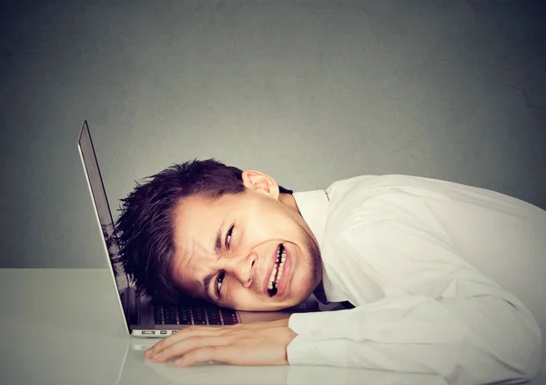 绝望的业务人用笔记本电脑键盘上的头 — 图库照片