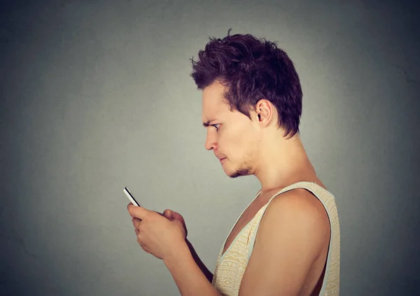 Furioso hombre viendo aplicaciones en el teléfono inteligente —  Fotos de Stock
