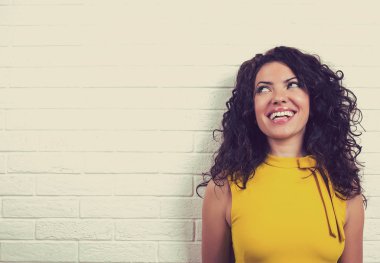 Mutlu kadın gülüyor, tuğla duvar arka plan üzerinde izole