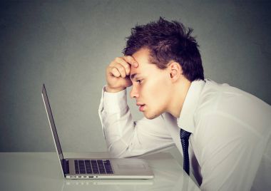Onun laptop önünde masada oturan üzgün adam mutsuz vurguladı 